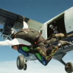 Experience the thrill of tandem skydiving as a pair leaps from an airplane over Wisconsin.