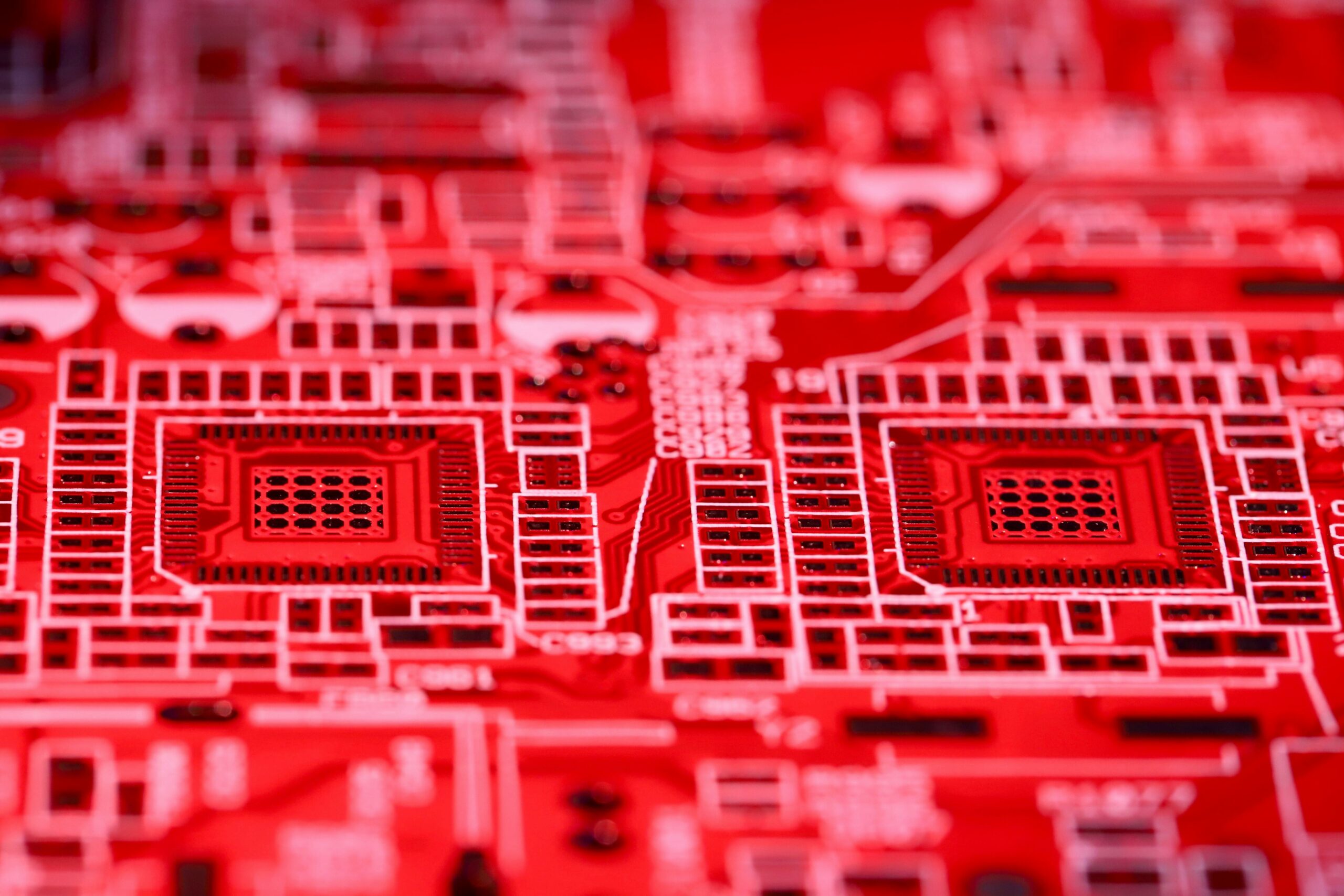 Detailed close-up of a red printed circuit board showcasing intricate electronic components and pathways.